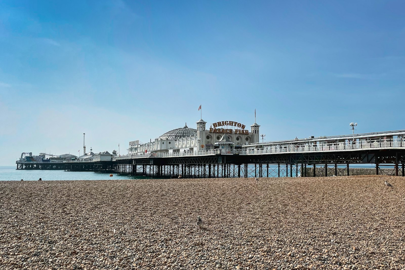 Brighton Palace Pier and the beach under a blue sky, inside the 01273 area
